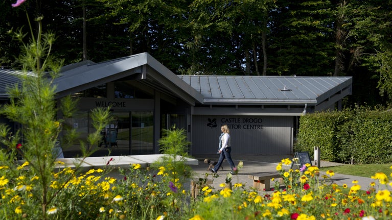 A woman walking into the visitor centre at Castle Drogo
